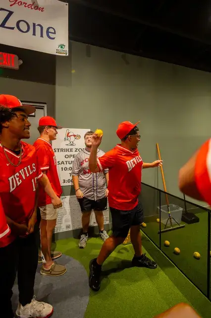Players in red jerseys try the Strike Zone pitching game.