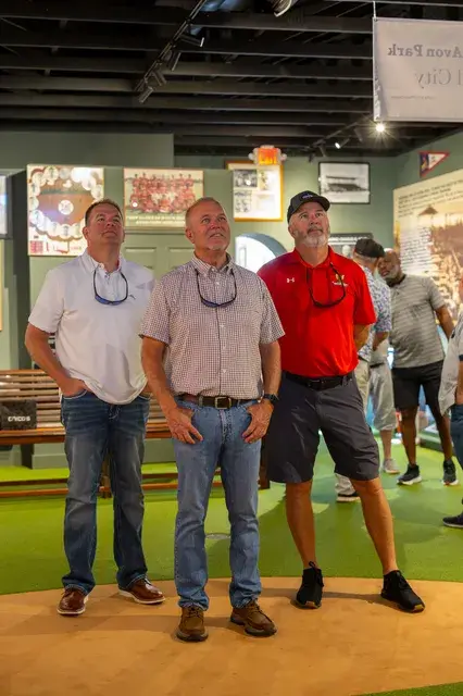 Three men pose on the gallery turf.