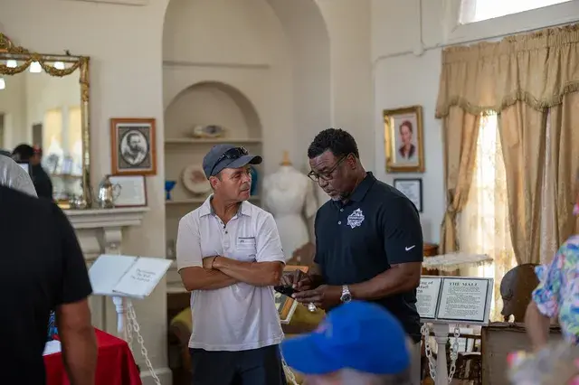 Two men talk in the Depot's parlour exhibit.