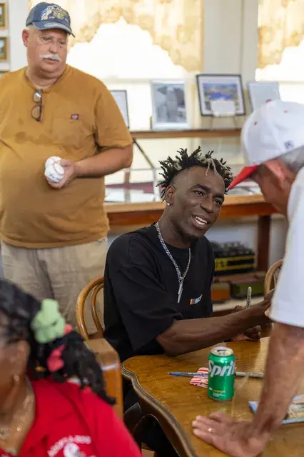 A man signs at a table inside the Depot.