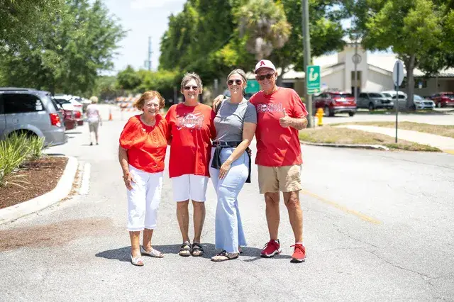 Four people in red pose in the street.