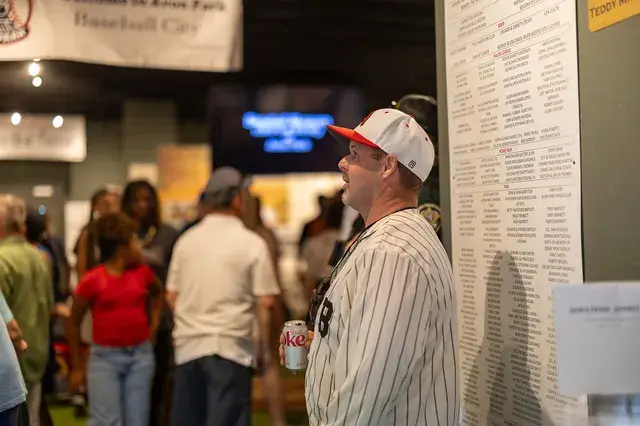 A man in a pinstriped jersey reads a wall of records inside the museum.