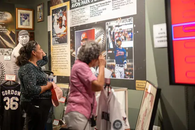 Visitors look at a panel about a player, a Gordon 36 jersey below it.