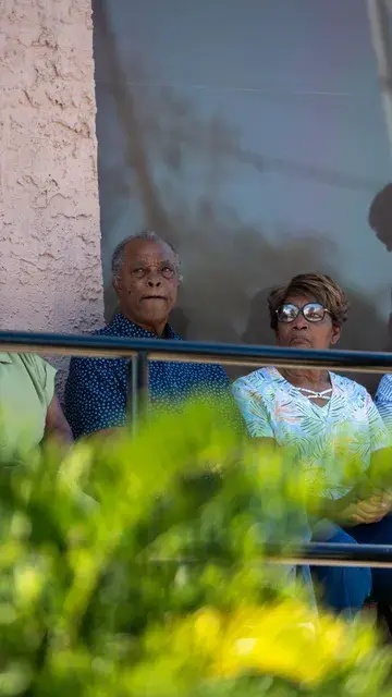 Two guests watch the ceremony from behind the porch railing.