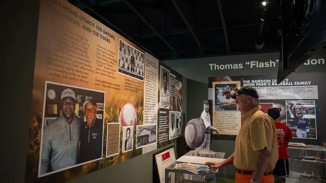 Guests read the Thomas Flash Gordon exhibit panels and a case of memorabilia.