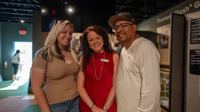Three guests pose inside the museum.