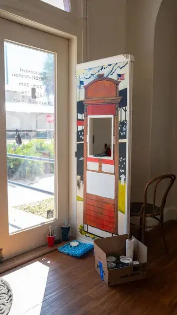 The ticket-booth doorway panel in the window light.