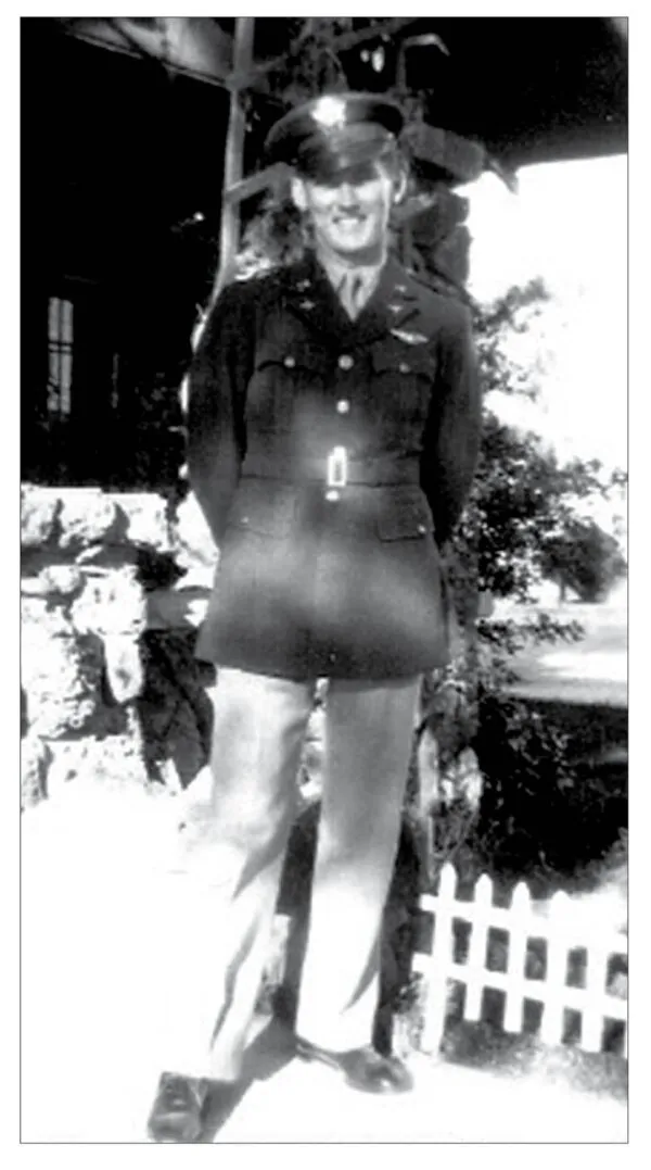 Pharis Weekley in his Army Air Forces uniform and cap, standing by a picket fence.